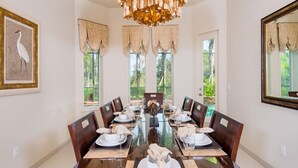 A dining room with a large oval table set for a meal, surrounded by chairs. - Ov3978 - Formosa Gardens - 7 Bed 7.5 Baths Villa (Kissimmee)