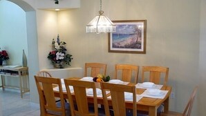 Ein Essbereich mit Holztisch und Stühlen, einer Hängelampe und einem gerahmten Bild an der Wand.