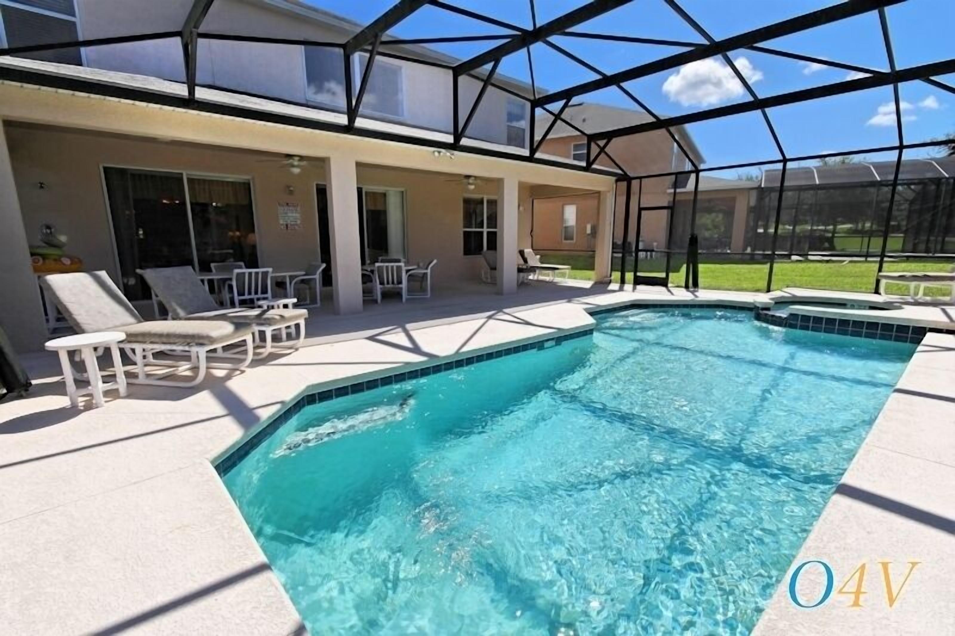 A swimming pool with lounge chairs and a covered patio area.