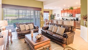 A spacious living room with a large sofa set, a coffee table, and a dining area with chairs. - Ov4009 - Windsor Hills Resort - 4 Bed 4 Baths Villa (Kissimmee)