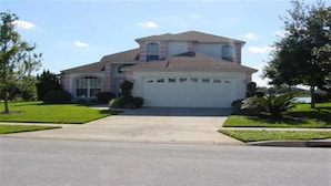 A two-story house with a garage, a driveway, and a well-maintained lawn. - Ov64 - Oak Island Harbour - 3 Bed 2.5 Baths Villa (Kissimmee)