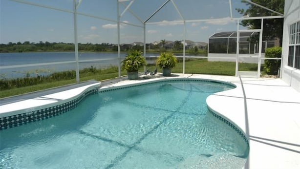 A swimming pool with a clear view of a lake and houses in the background. - Ov64 - Oak Island Harbour - 3 Bed 2.5 Baths Villa (Kissimmee)