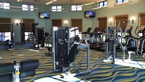 A gym with various exercise machines, large windows, and a patterned carpet. - Ov3992 - Champions Gate Resort - 8 Bed 5 Baths Villa (Davenport)