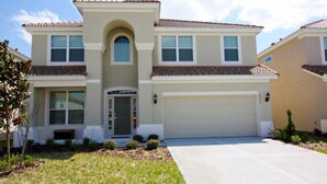 A two-story house with a central entrance, a garage, and a well-maintained lawn.