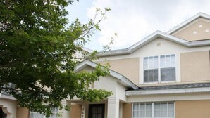 A two-story building with a beige facade, a black door, and a fire safety sign. - Ov4200 - Windsor Hills Resort - 3 Bed 3 Baths Villa (Kissimmee)