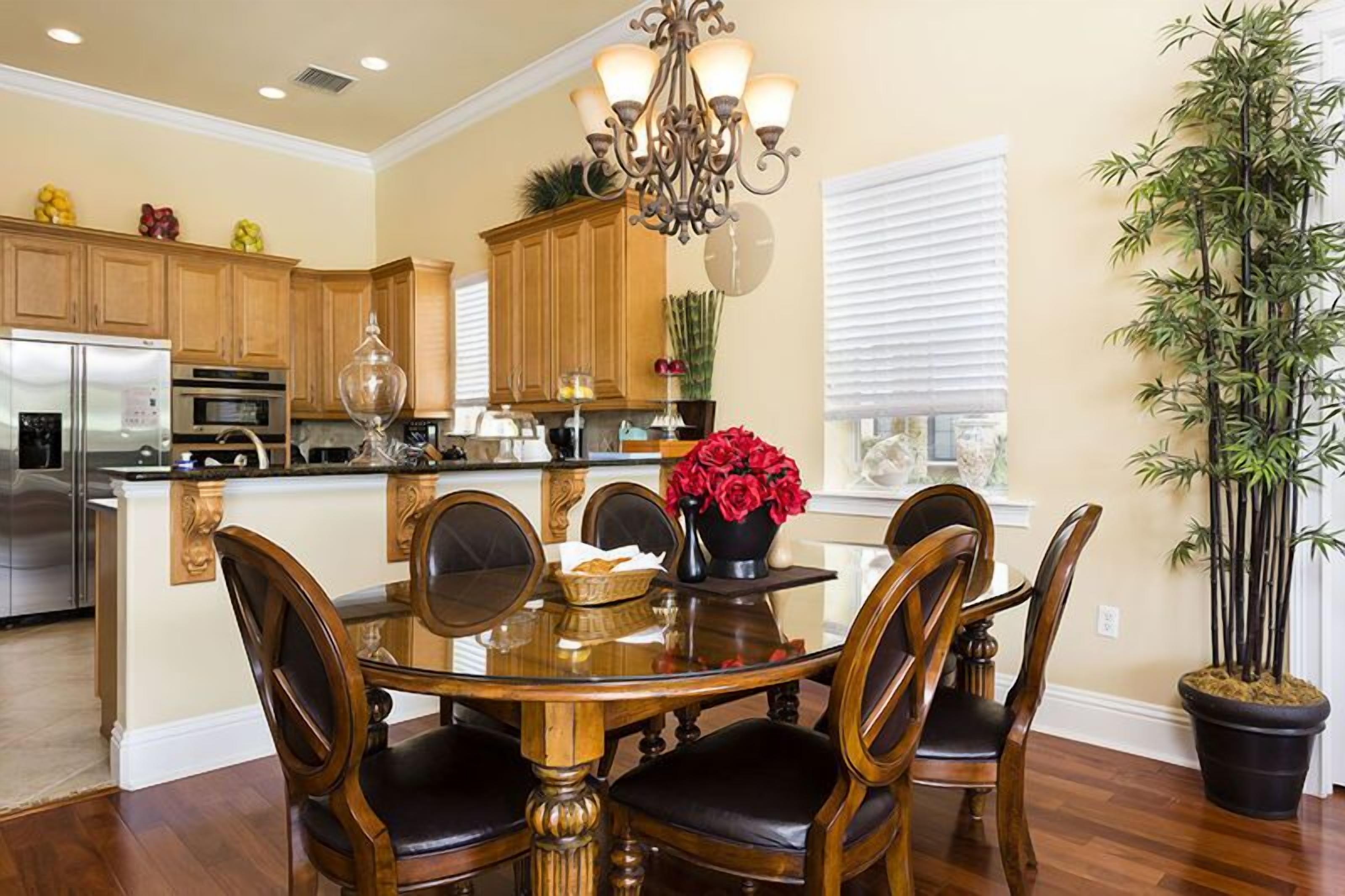 Una cocina con armarios de madera, una isla central y una mesa de comedor con sillas.