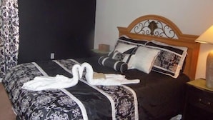 A bed with a black and white patterned bedspread, two white towels, and decorative pillows. - Ov3786 - Cumbrian Lakes - 4 Bed 3.5 Baths Villa (Kissimmee)