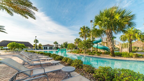 A pool area with lounge chairs and a water slide.