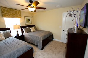 A bedroom with two beds, a ceiling fan, a lamp, a dresser, and a television. - Ov4182 - Champions Gate Resort - 8 Bed 5 Baths Villa (Davenport)