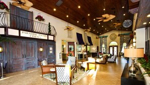 A spacious lobby with a reception desk, seating area, and a sign for Paradise Palms Cinema.
