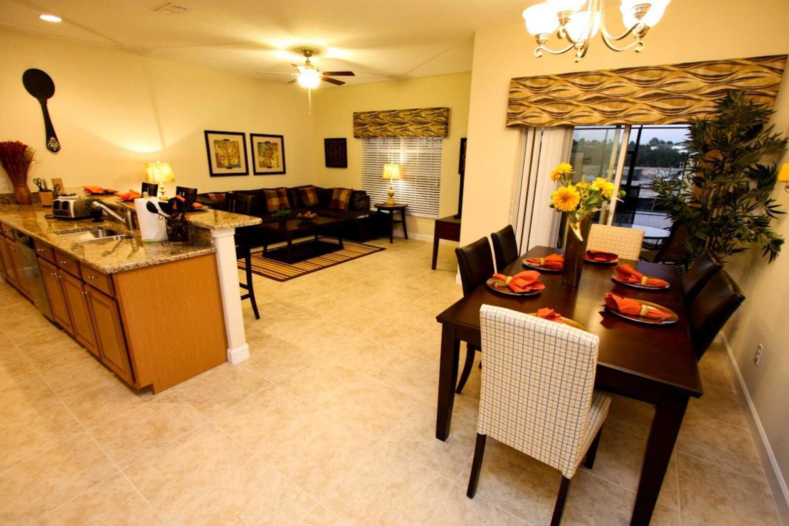 Amplia sala de estar con cocina, mesa de comedor y asientos.