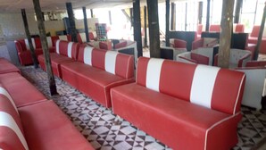 A row of red and white striped benches with a checkered floor pattern. - Maverick Camp Rondavels and Homestay (Aberdare National Park)