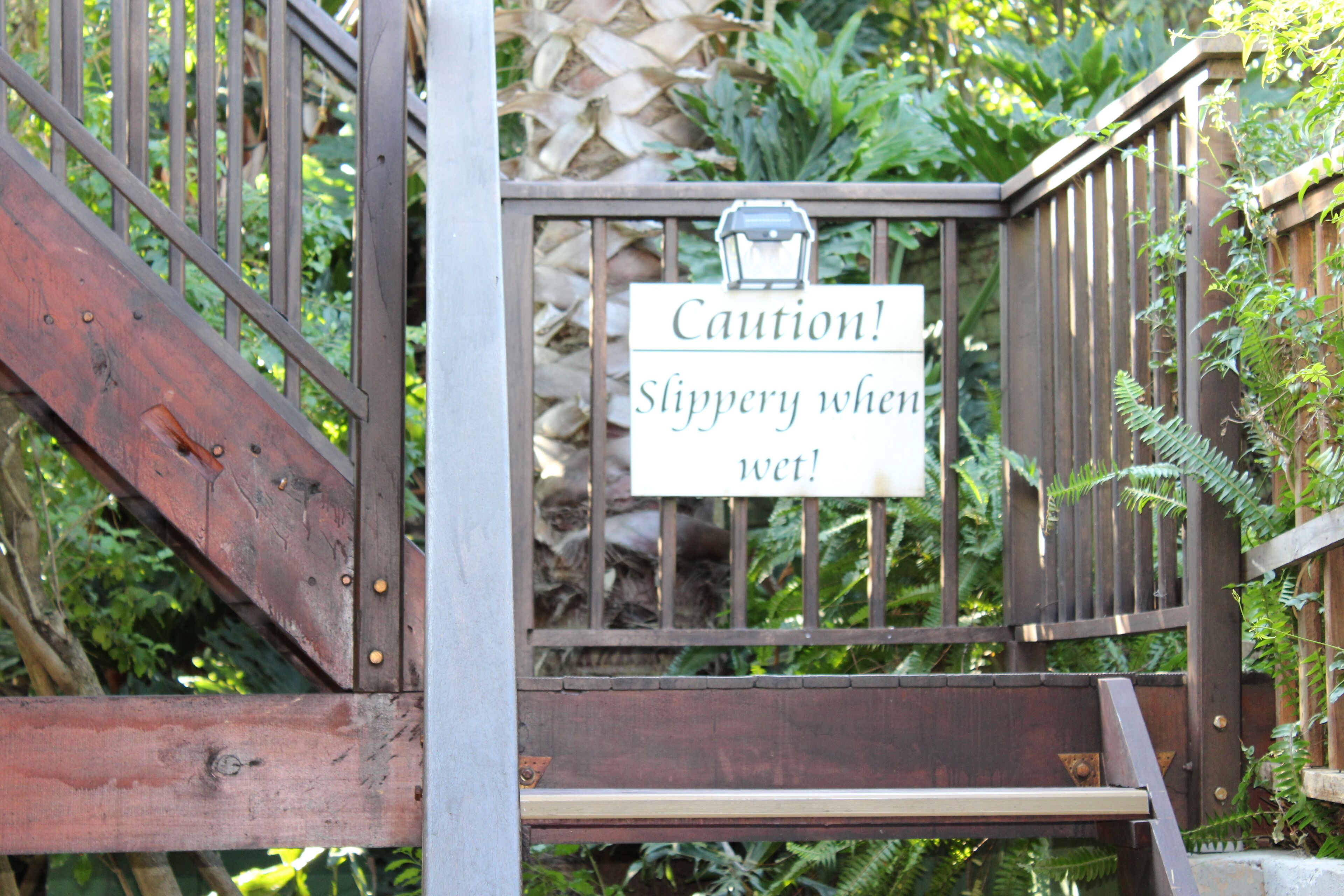 A caution sign warning of slippery steps.