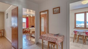 A modern interior with a dining area, a kitchen, and a view of the outdoors. - 2-room apartment with balcony and parking in Megève (Megève)