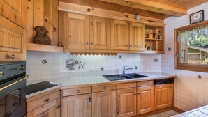 Une cuisine avec des meubles de rangement en bois, un évier et une cuisinière.