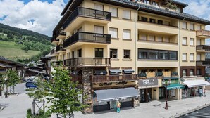 A multi-story hotel with balconies, a storefront, and a view of the surrounding area.