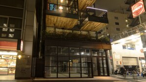 A multi-story building with balconies, large windows, and a ground-level entrance. - bnb+ Kanda - Hostel (Tokyo)