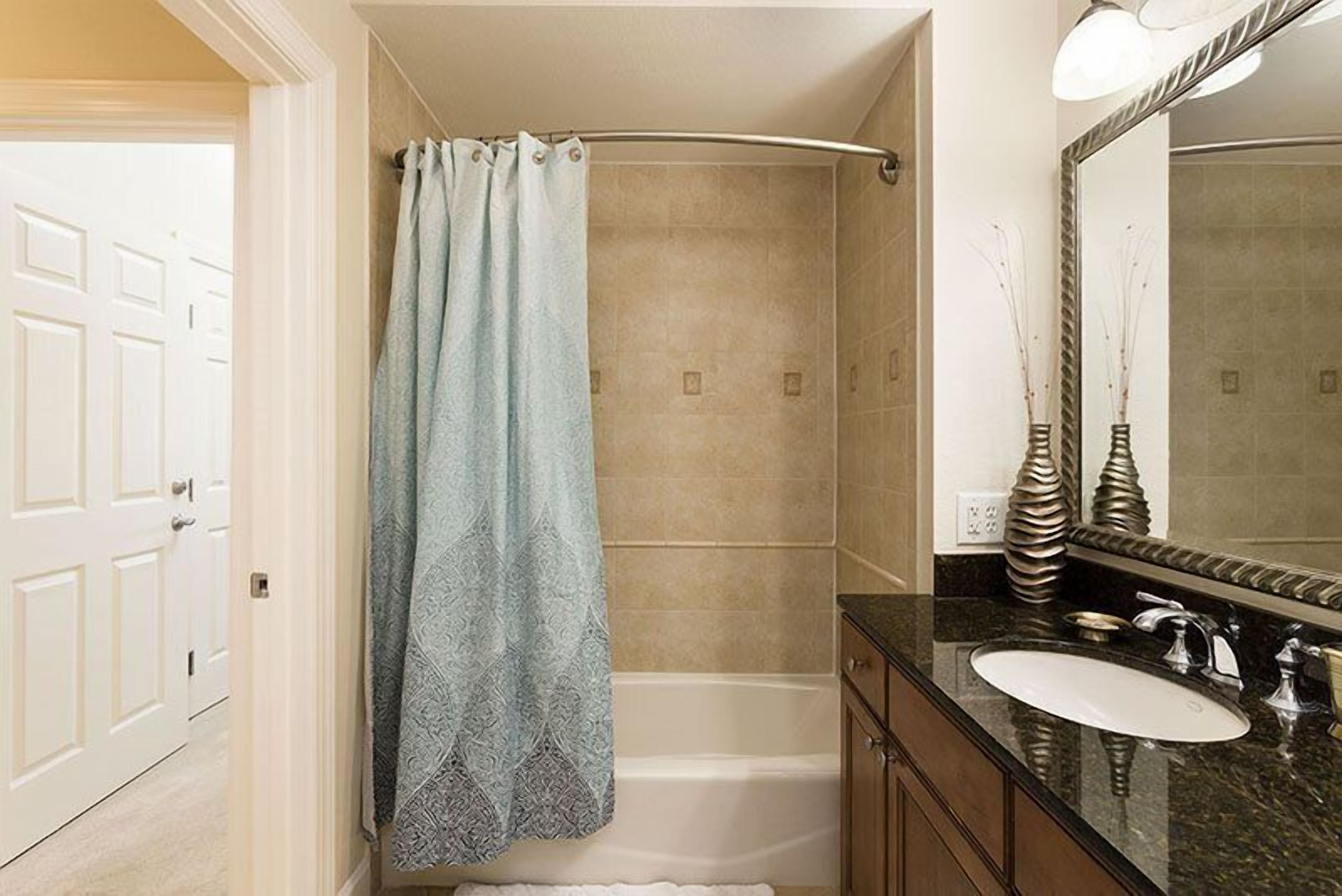 A bathroom with a shower, a bathtub, a sink, and a mirror.