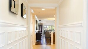A hallway with white wainscoting and a tiled floor leading to a kitchen area. - Ov4262 - Reunion Resort - 3 Bed 3 Baths Condo (Kissimmee)