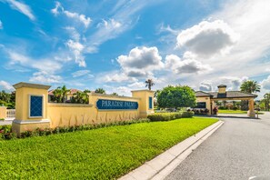 A well-maintained entrance with a sign reading "Paradise Palms" and a clear pathway leading to the building.