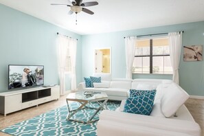 Relax in this stylish living room with a sofa, coffee table, flat-screen TV, and large windows.