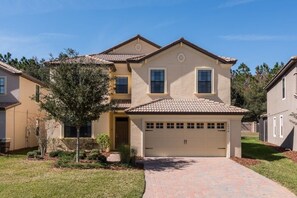Stunning two-story residence with a central entrance, double doors, and a garage.