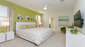 A bedroom with a bed, nightstands, a green armchair, a dresser, and artwork on the walls. - Ev228681 - Champions Gate Resort - 8 Bed 5 Baths Villa (Davenport)