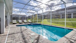 A covered swimming pool with lounge chairs, a brick deck, and a view of a residential area. - Ev228681 - Champions Gate Resort - 8 Bed 5 Baths Villa (Davenport)