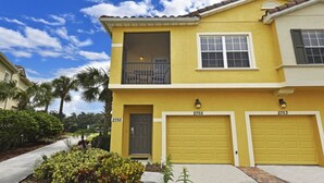 A two-story yellow building with a balcony, two garage doors, and a number 2755 garage door. - Fs55568 - Oakwater Resort - 2 Bed 2 Baths Townhome (Kissimmee)