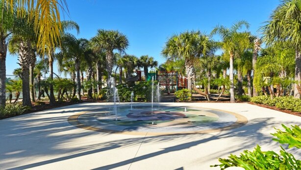 A circular water feature with a fountain in the center, surrounded by palm trees and greenery. - Fs55568 - Oakwater Resort - 2 Bed 2 Baths Townhome (Kissimmee)