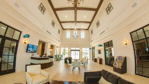 A spacious lobby with a high ceiling, chandeliers, and a reception desk. - Fd88884 - Windsor At Westside Resort - 5 Bed 4.5 Baths Townhouse (Kissimmee)