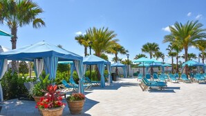 A poolside area with blue canopies, lounge chairs, and potted plants. - Fd88884 - Windsor At Westside Resort - 5 Bed 4.5 Baths Townhouse (Kissimmee)