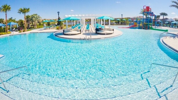 A large, clear swimming pool with a central water slide and surrounding lounge areas. - Fd88884 - Windsor At Westside Resort - 5 Bed 4.5 Baths Townhouse (Kissimmee)