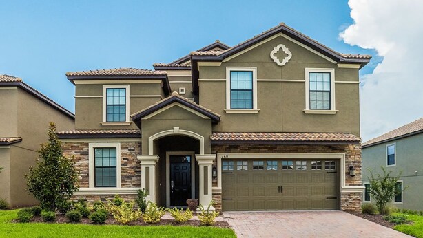A two-story house with a stone facade, a front entrance with a door, and a garage.