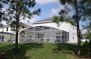 A modern building with a large glass enclosure, surrounded by trees and a well-maintained lawn. - Ev54115 - Highlands Reserve - 5 Bed 3 Baths Villa (Davenport)