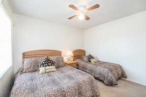 A bedroom with two beds, a ceiling fan, and a nightstand with a lamp. - Ev54115 - Highlands Reserve - 5 Bed 3 Baths Villa (Davenport)