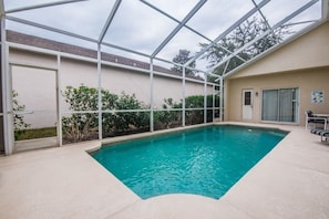 An indoor swimming pool with a glass ceiling, surrounded by a beige wall and greenery. - Ev215108 - The Abbey at West Haven - 4 Bed 3 Baths Villa (Davenport)