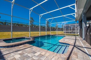 A covered outdoor swimming pool with a brick deck and a clear blue sky in the background. - Ev242169 - Champions Gate Resort - 8 Bed 5 Baths Villa (Davenport)