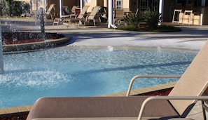 A pool with a water feature, surrounded by lounge chairs and a building in the background. - Fd57055 - Lucaya Village - 4 Bed 3 Baths Townhouse (Kissimmee)