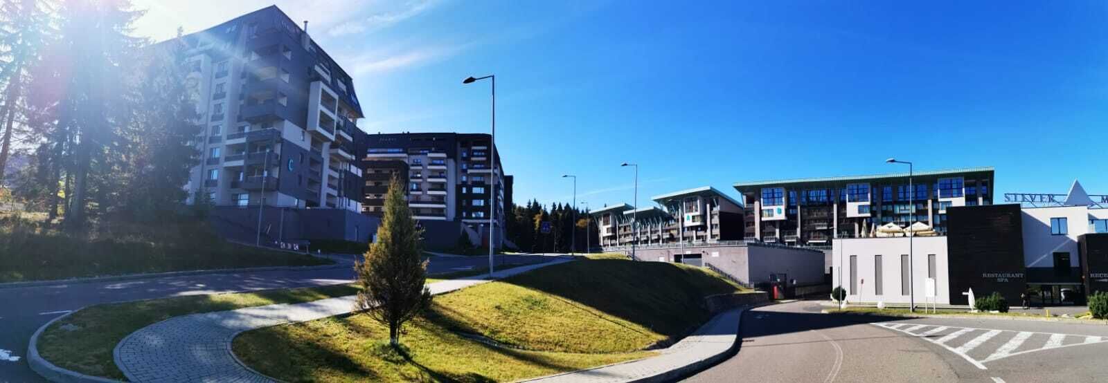 Un ensemble immobilier moderne composé de plusieurs bâtiments, doté d’une cour intérieure et d’une promenade piétonne.