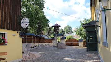 A cobblestone street with a sign for a bowling alley, wooden buildings, and a green door.