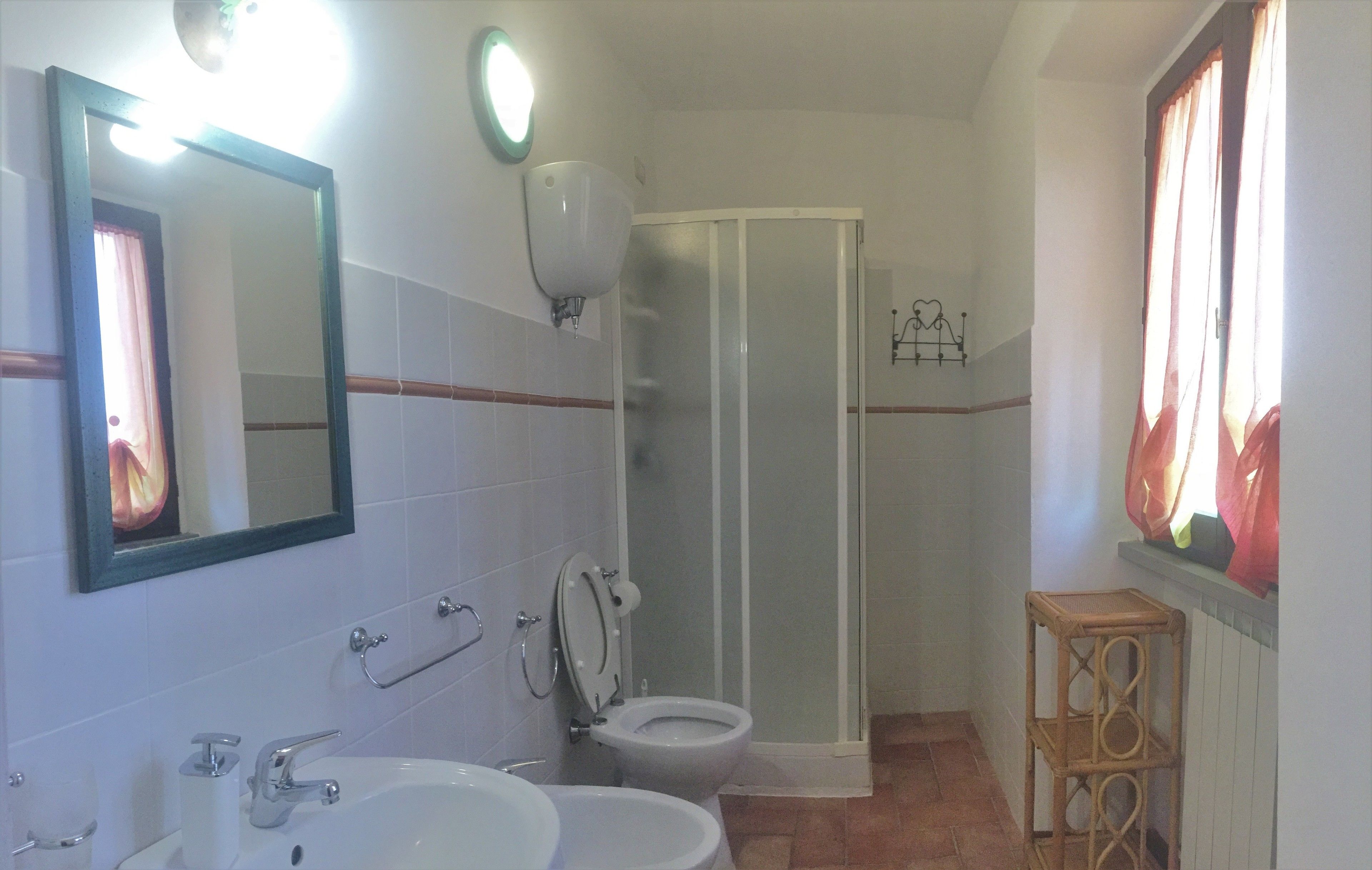 A bathroom with two sinks, a toilet, a shower, and a mirror.