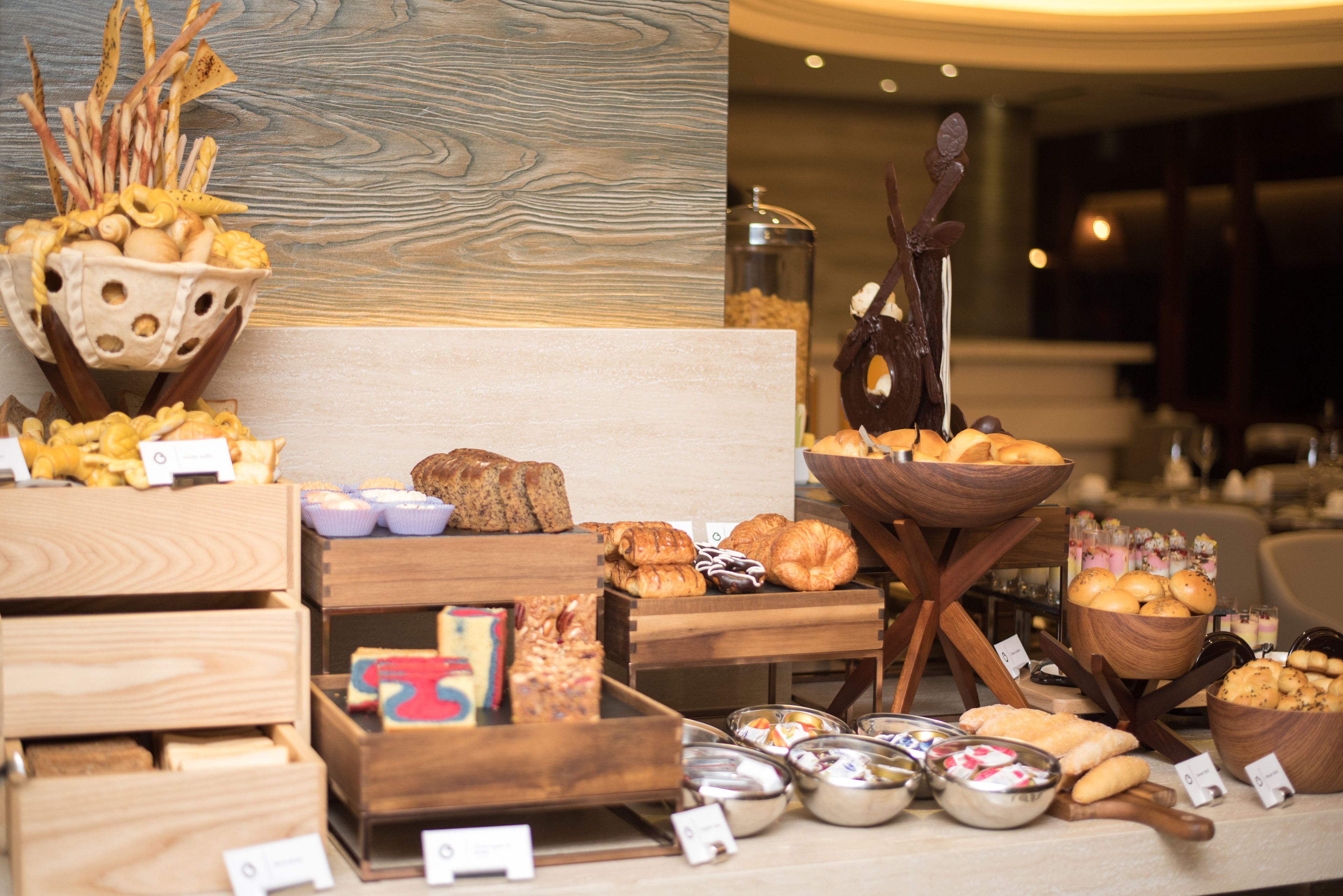 Un bufé con diversos alimentos y bandejas de madera.