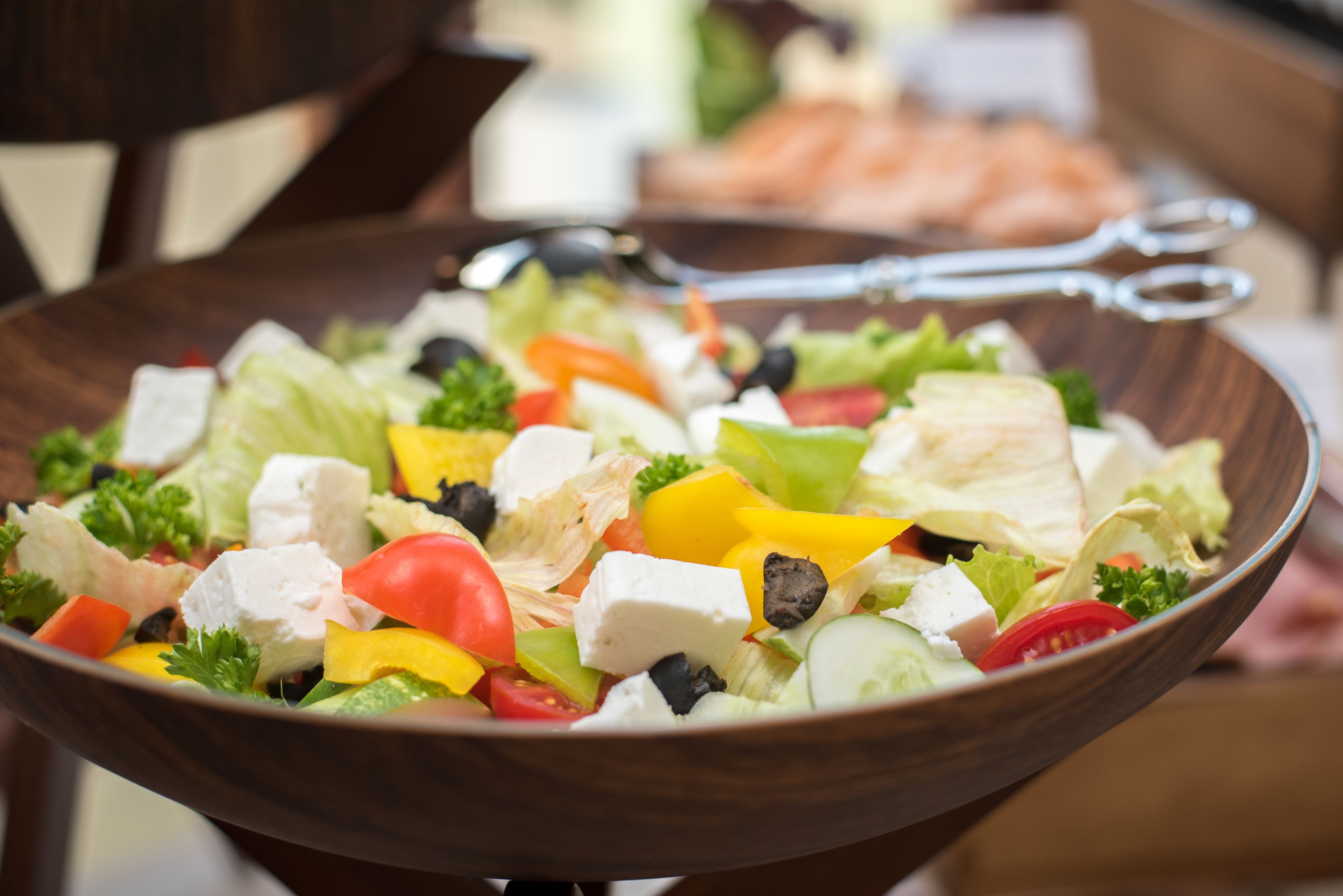 Uma tigela de madeira com uma salada colorida.