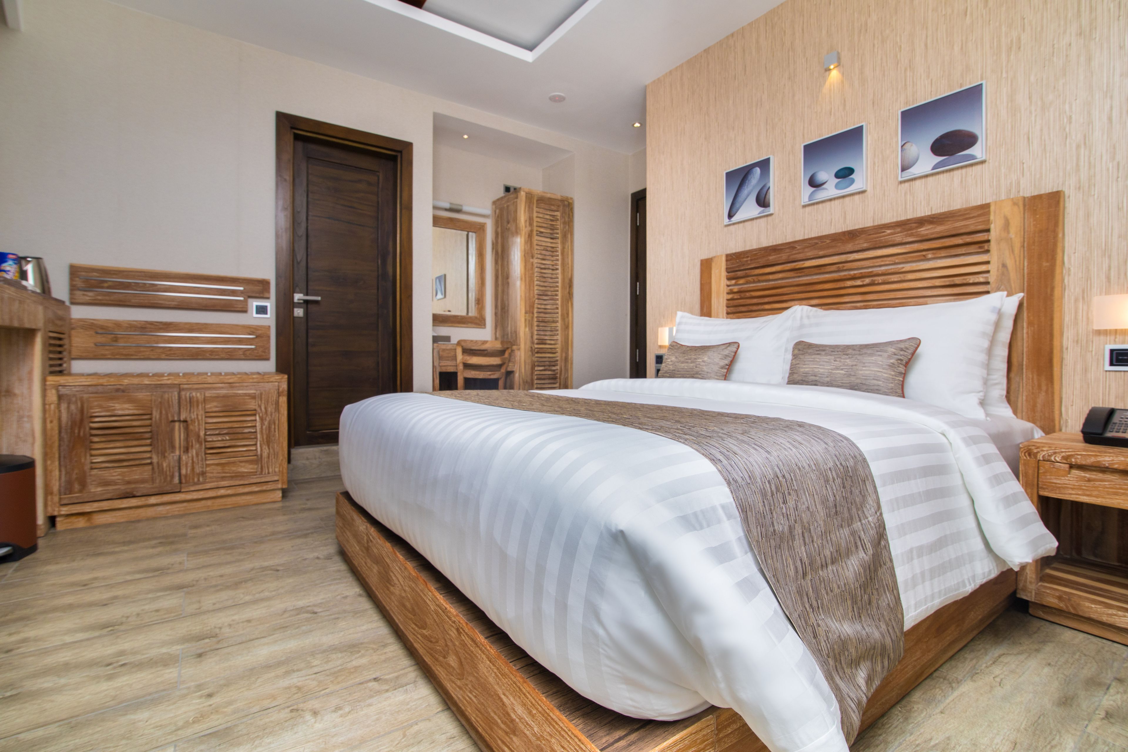 Un dormitorio moderno con una cama grande, cabecera de madera y tragaluz.