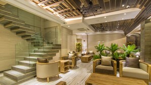 A modern interior with a glass staircase, wooden furniture, and indoor plants.