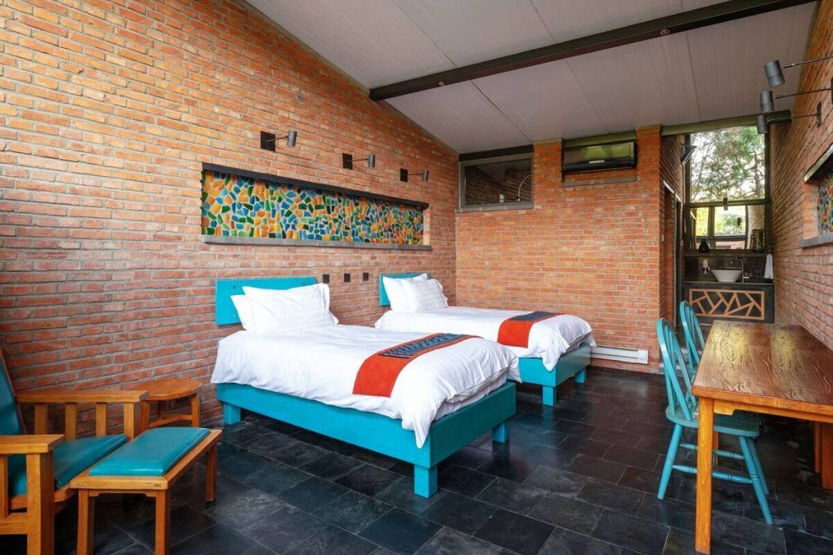 A room with two beds, a dining table, and chairs.