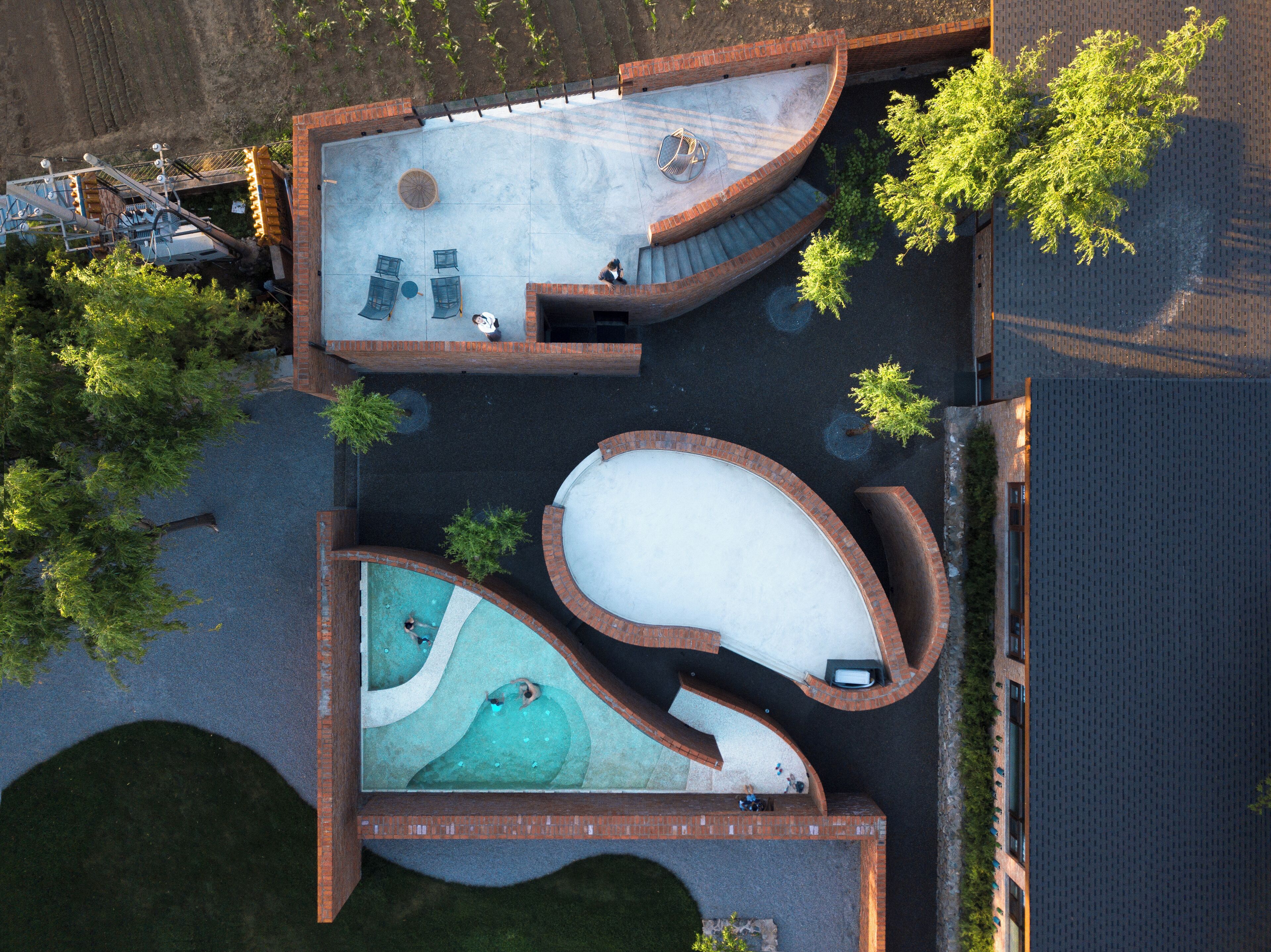 An aerial view of a swimming pool complex with multiple interconnected pools and a patio area.