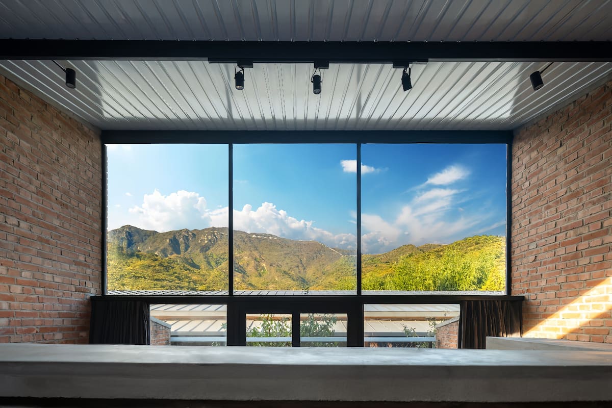 A room with a large window offering a view of a mountainous landscape.