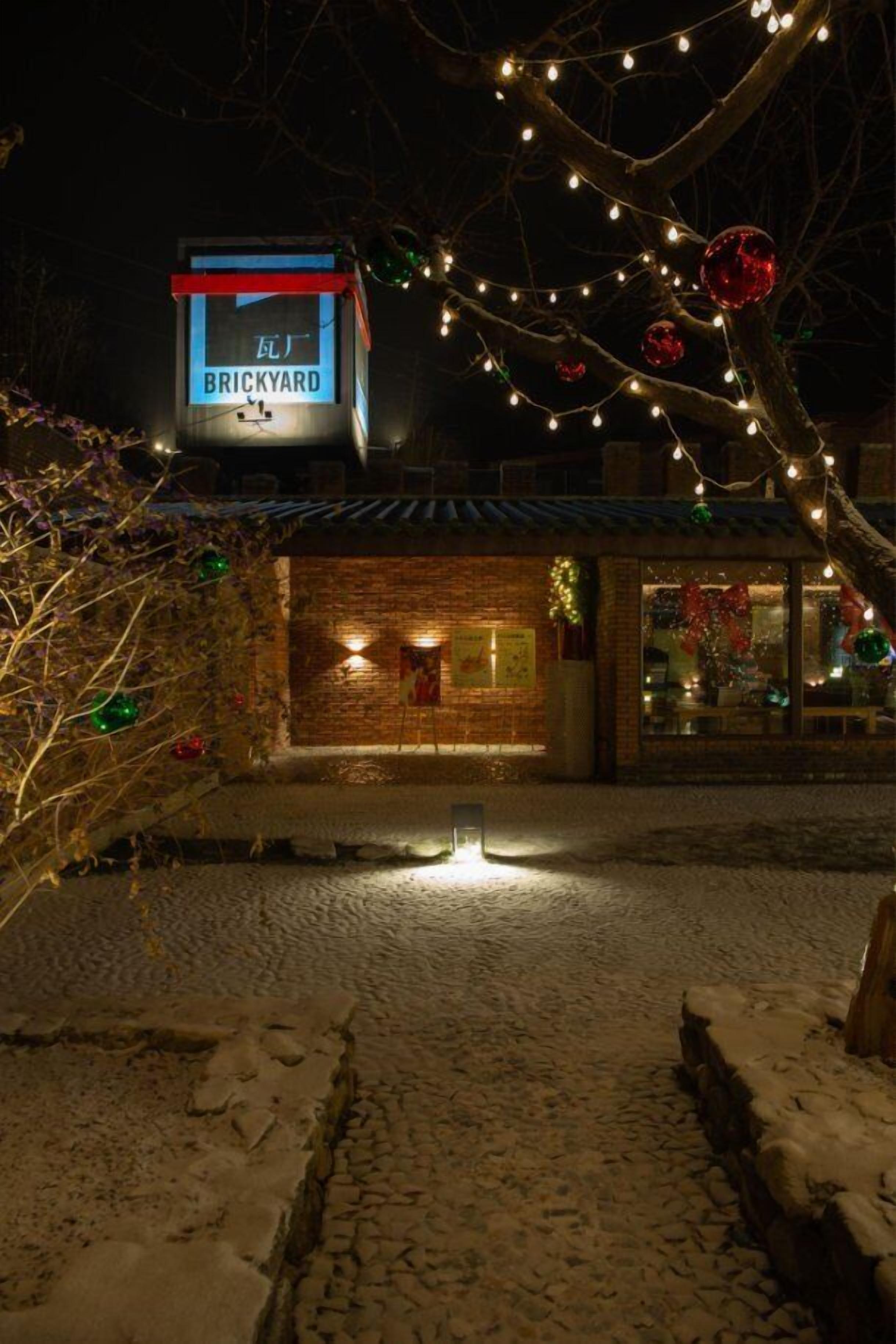 Un edificio de ladrillo con un letrero que dice "BRICKYARD" y un árbol de Navidad con luces.